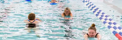 adults swimming in indoor pool