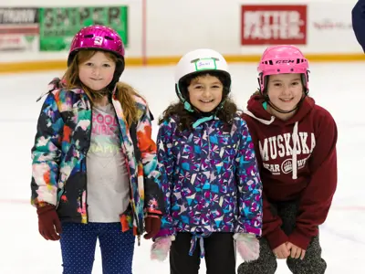three youths taking photo together while ice skating