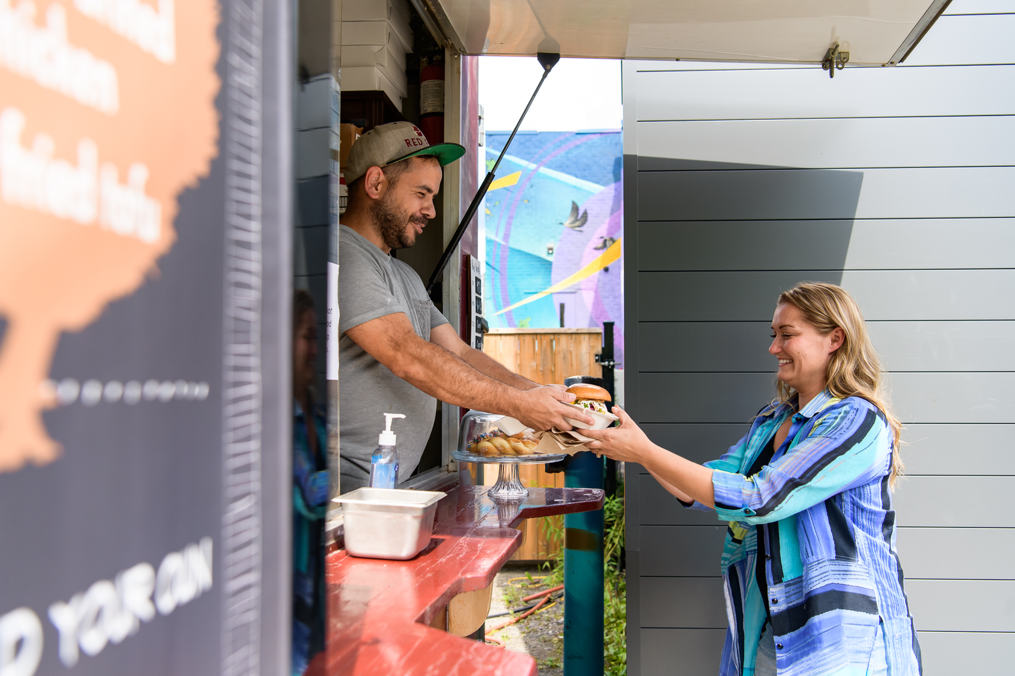 food truck worker handing off item to customer